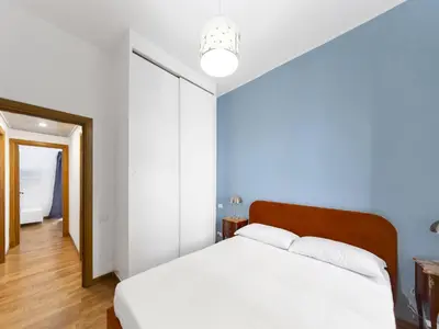 a bedroom with a white bed and a blue wall at (Piazza di spagna)Rome Apartment in Rome