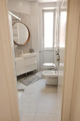 a bathroom with a toilet and a sink and a mirror at Family apartment near Vatican Museum in Rome