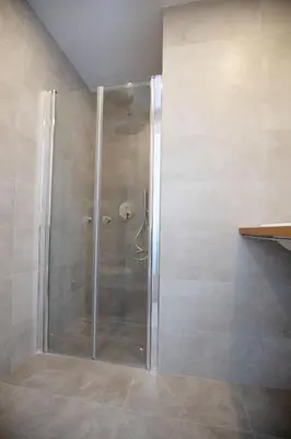 a shower with a glass door in a bathroom at Domus Cordara - Splendido appartamento nel verde in Rome