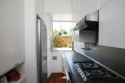 a kitchen with a stove top oven next to a window at Domus Cordara - Splendido appartamento nel verde in Rome