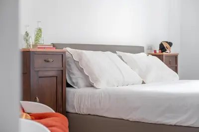 a bedroom with a bed with white pillows and a night stand at iFlat Wood and Marble Riverfront in Rome