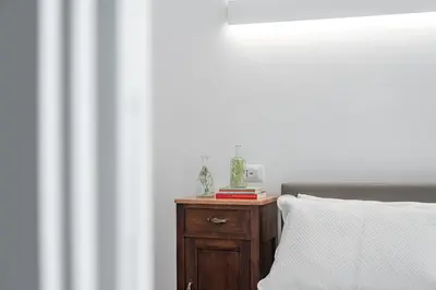 a bedroom with a bed and a wooden nightstand with a pillow at iFlat Wood and Marble Riverfront in Rome
