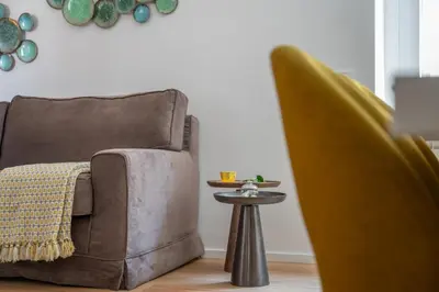 a chair and a side table in a living room at iFlat Wood and Marble Riverfront in Rome