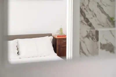 a bedroom with a bed and a table with a white pillow at iFlat Wood and Marble Riverfront in Rome