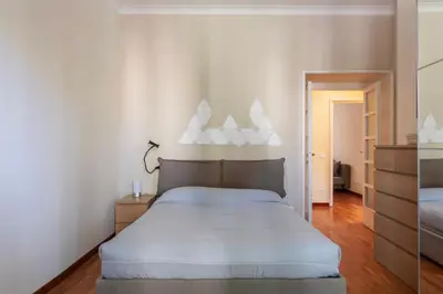 a bedroom with a large bed with white sheets at GuestHost - Rione Prati Comfy Apartment in Rome