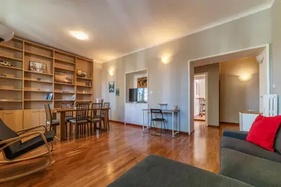 a living room with a couch and a dining room at GuestHost - Rione Prati Comfy Apartment in Rome