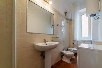 a bathroom with a sink and a toilet and a mirror at GuestHost - Rione Prati Comfy Apartment in Rome