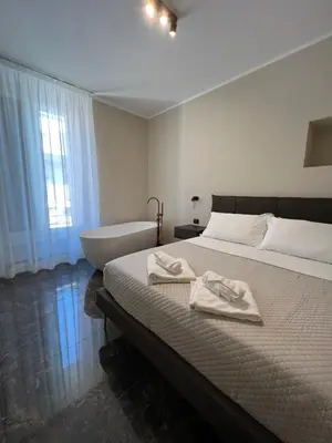 a bedroom with a bed with a bathtub and a bed with towels at Viminale Domus in Rome