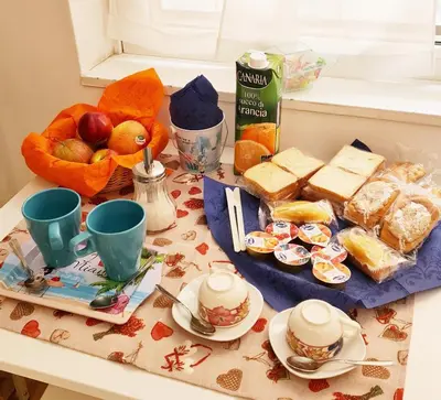 a table with a breakfast of cheese bread and fruit at B&B La stanza di Zoe - Roma Tre Metro B Marconi in Rome