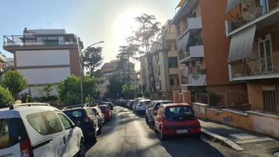 a row of cars parked on a city street at B&B La stanza di Zoe - Roma Tre Metro B Marconi in Rome