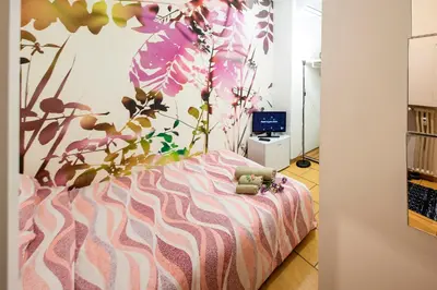 a bedroom with a bed with a flower mural on the wall at B&B La stanza di Zoe - Roma Tre Metro B Marconi in Rome