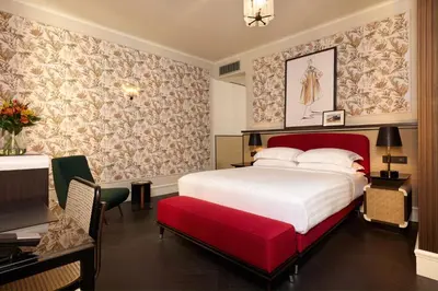 a bedroom with a large white bed and a red bench at TB Place Roma in Rome