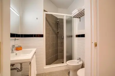 a bathroom with a shower and a toilet and a sink at Roma In Una Stanza Guesthouse in Rome