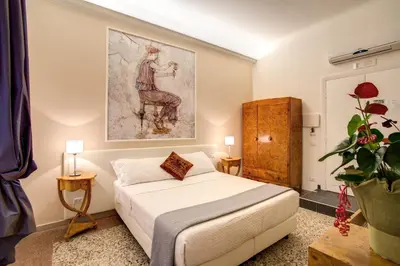 a bedroom with a bed and a painting on the wall at Roma In Una Stanza Guesthouse in Rome