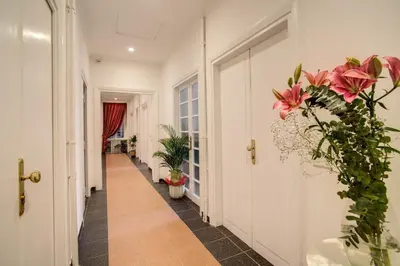 a hallway with pink flowers and plants at Roma In Una Stanza Guesthouse in Rome