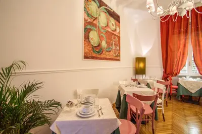 a restaurant with tables and chairs and a painting on the wall at Roma In Una Stanza Guesthouse in Rome