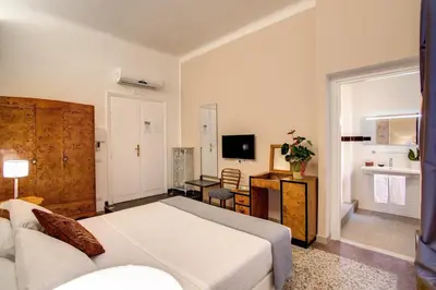 a bedroom with a bed and a living room at Roma In Una Stanza Guesthouse in Rome