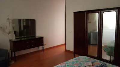a bedroom with a dresser and a mirror and a bed at Casa Vacanze Yuli in Rome