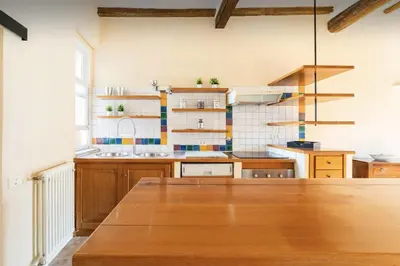 a large kitchen with wooden cabinets and a wooden table at Piazza Navona Center House in Rome