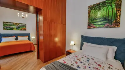 a bedroom with a bed and a wooden floor at Karisma Suites in Rome