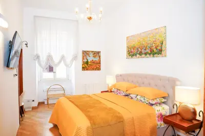 a bedroom with a bed and a painting on the wall at Karisma Suites in Rome