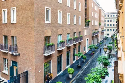 an apartment building with plants on the balconies at Frezza Charming Suite in Rome