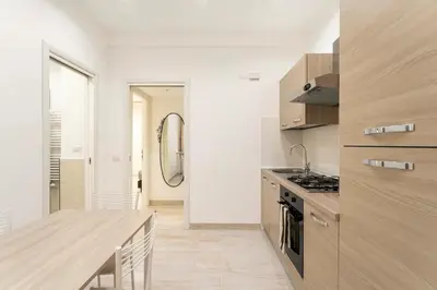 a kitchen with a wooden counter top and a table at First Floor Apartment in Rome