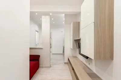a living room with a red couch and a television at First Floor Apartment in Rome