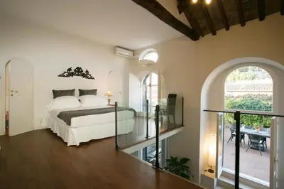 a bedroom with a bed and a balcony at Your Prestigious Penthouse at the Spanish Steps in Rome