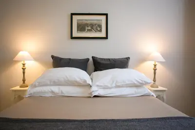 a bed with two white pillows and two lamps at Your Prestigious Penthouse at the Spanish Steps in Rome