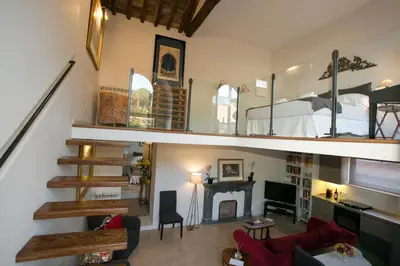 a living room with a bedroom and a bed and a fireplace at Your Prestigious Penthouse at the Spanish Steps in Rome