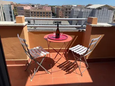 a bottle of beer sitting on a table on a balcony at Caracciolo33 in Rome