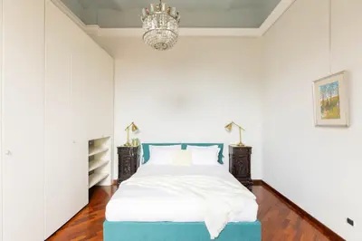a bedroom with a bed and a chandelier at Colosseum Perfect Apartment in Rome