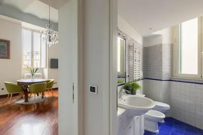a bathroom with a sink and a toilet and a table at Colosseum Perfect Apartment in Rome