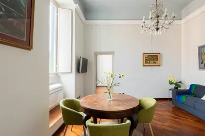 a living room with a table and green chairs at Colosseum Perfect Apartment in Rome