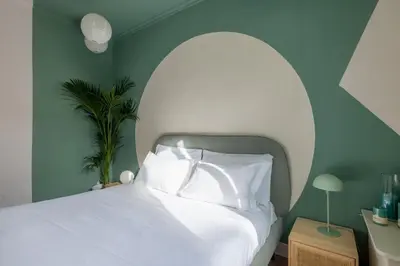 a bedroom with a white bed with an arched headboard at ARIA Penthouse & Garden in Rome