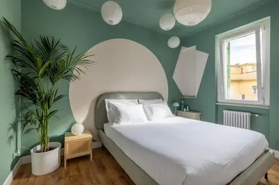 a bedroom with a white bed and a green wall at ARIA Penthouse & Garden in Rome
