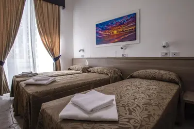 a hotel room with two beds with towels on them at Hotel Orbis in Rome