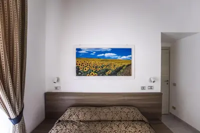 a bedroom with a bed and a painting on the wall at Hotel Orbis in Rome