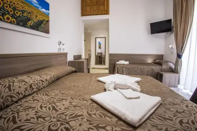 a hotel room with a bed with two towels on it at Hotel Orbis in Rome