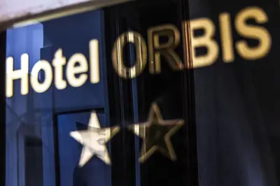 a reflection of a hilton hotel sign in a window at Hotel Orbis in Rome
