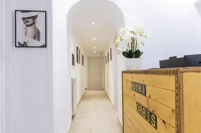 a hallway with a wooden dresser in a white room at Hotel Orbis in Rome