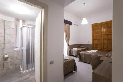 a room with two beds and a bathroom at Hotel Orbis in Rome