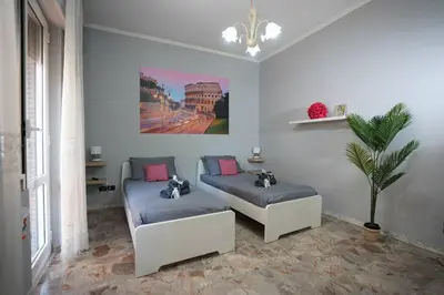 a living room with two beds and a plant at Big Flat Rome Metro C in Rome