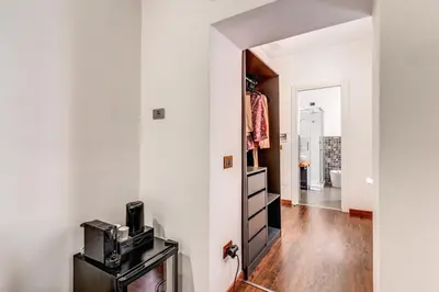 a hallway with a white wall and a door with a microwave at Effe Luxury Palace in Rome