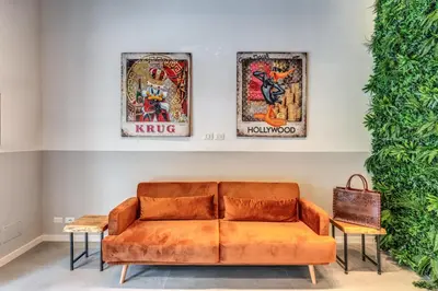 a couch in a room with three pictures on the wall at Effe Luxury Palace in Rome