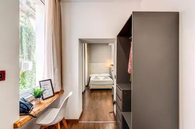 a small room with a desk and a bedroom at Effe Luxury Palace in Rome