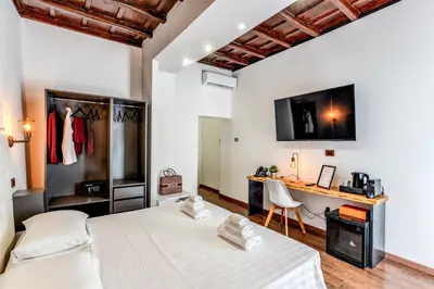 a bedroom with two beds and a desk in it at Effe Luxury Palace in Rome