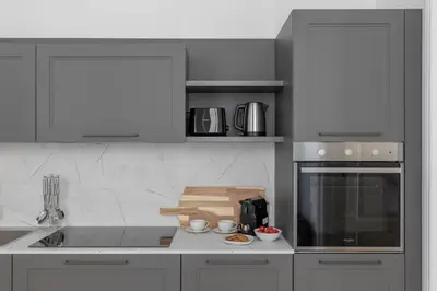 a kitchen with white cabinets and a counter top at iFlat Elegance and comfort in Monti in Rome
