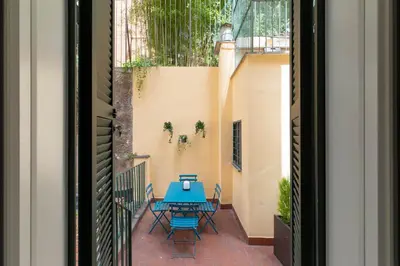 a patio with a blue table and chairs at iFlat Elegance and comfort in Monti in Rome